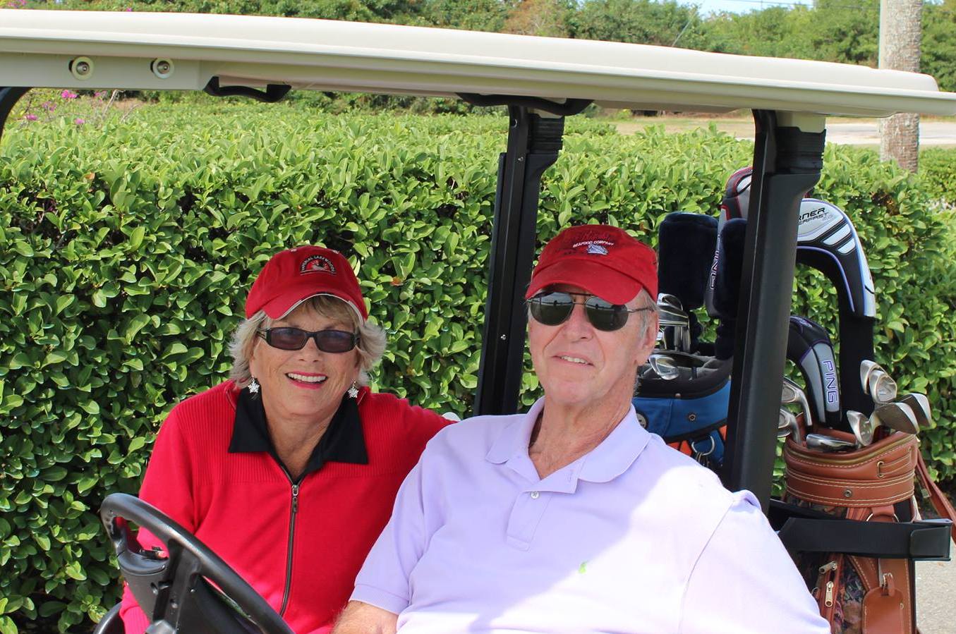 Gloria and Eric sitting in a golf cart